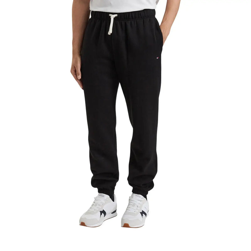 Schwarze Tommy Hilfiger Herren-Fleecehose aus Baumwollmischgewebe mit weißem Kordelzug und dezentem Logo am Oberschenkel (Vorderansicht)