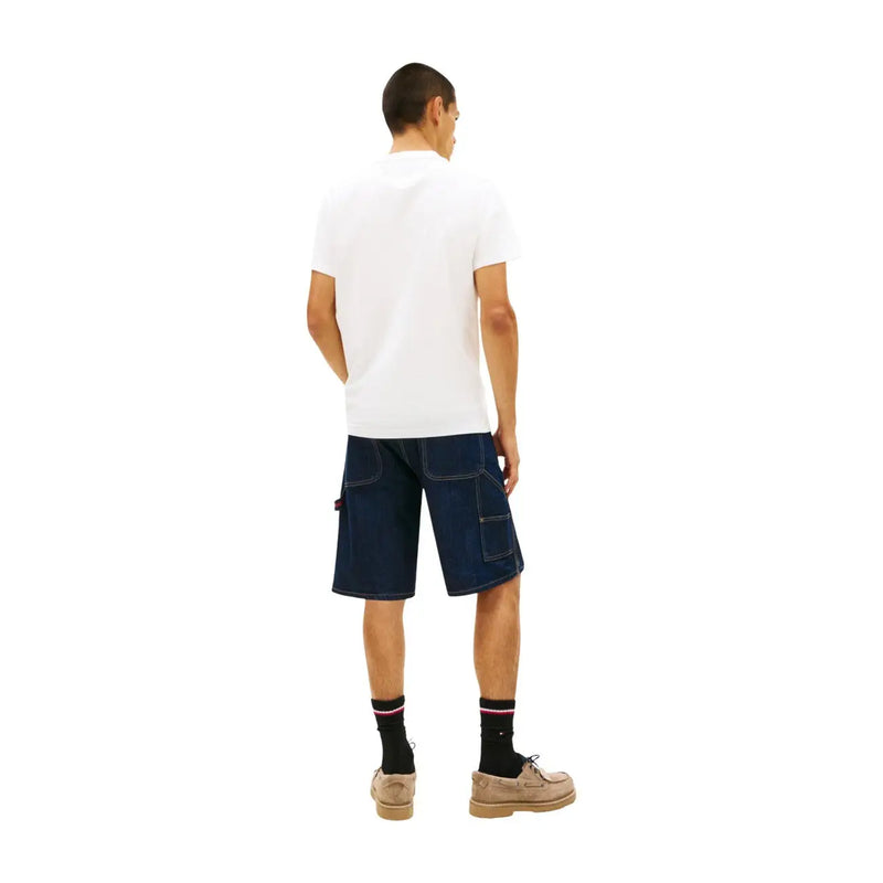 Dunkelblaue Cargo-Shorts aus Denim mit verstärkten Nähten und Seitentaschen, kombiniert mit einem weißen T-Shirt aus Bio-Baumwolle von Tommy Hilfiger für Herren.