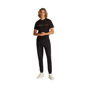 Tommy Hilfiger Herren-Fleecehose in Schwarz, schmal geschnitten, kombiniert mit einem schwarzen t-shirt mit weißen und rosa Streifen