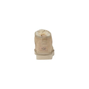 Beigefarbene UGG-Damenstiefel aus Wildleder mit weichem, weißem Futter und klassischem Logo-Patch – ideal für den Frühling.