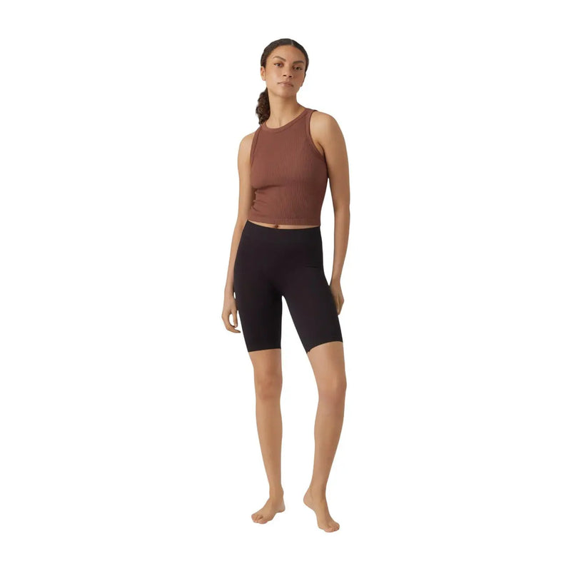 Eine Frau trägt vero moda Schwarze Nylon-Radlerhosen zum Hineinschlüpfen für Damen, kombiniert mit einem rostfarbenen, ärmellosen Crop-Top top