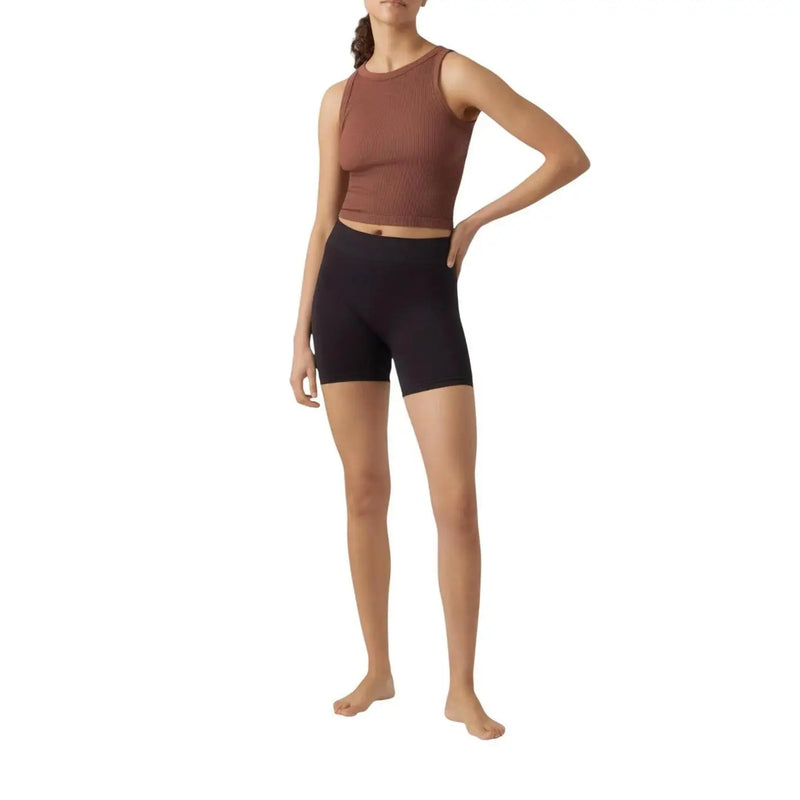 Ein geripptes, rostfarbenes, ärmelloses Crop-Top top mit hohem Ausschnitt kombiniert mit vero moda schwarze Polyamid-Elastan-Shorts